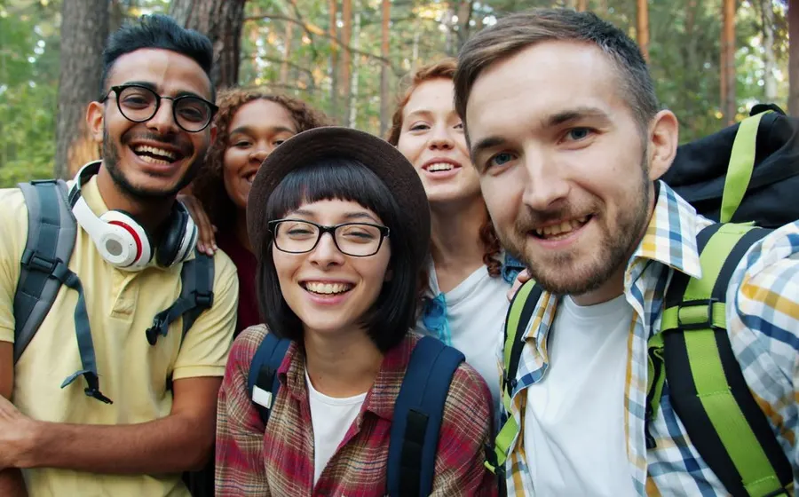 Multicultural friends taking a selfie during a forest hike
