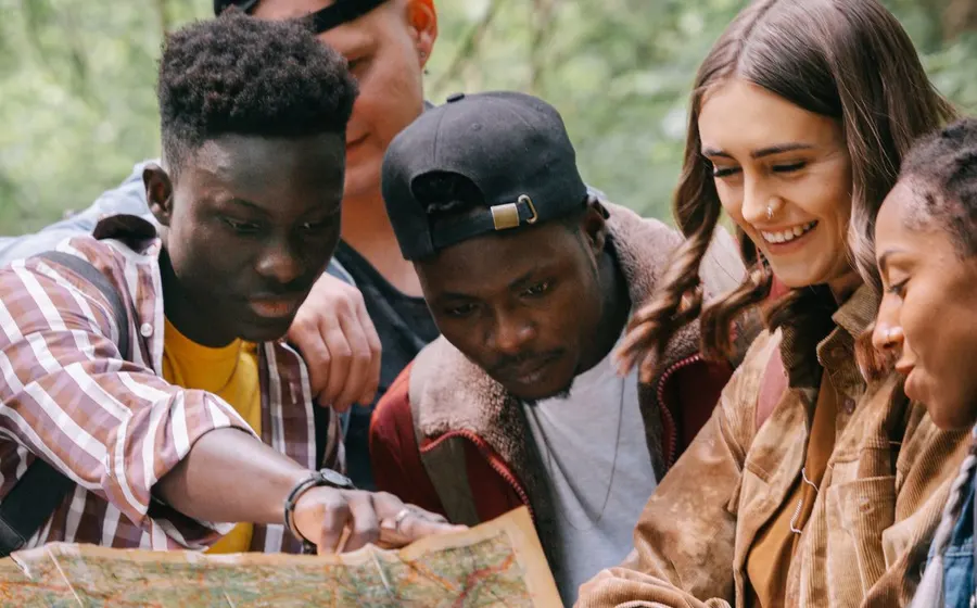 A diverse group of travellers planning their route with a map