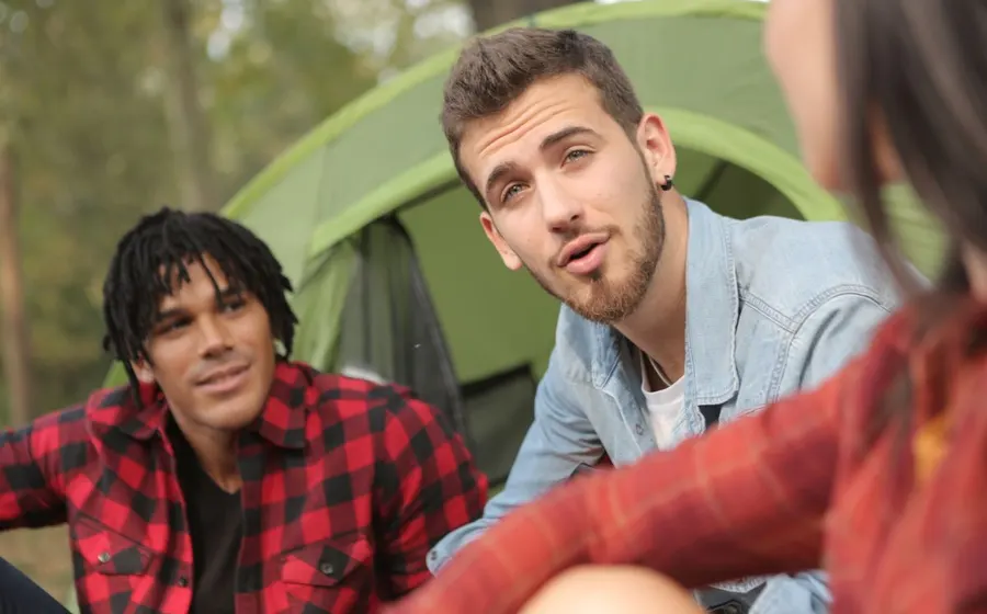 Friends from different backgrounds relaxing together at a campsite
