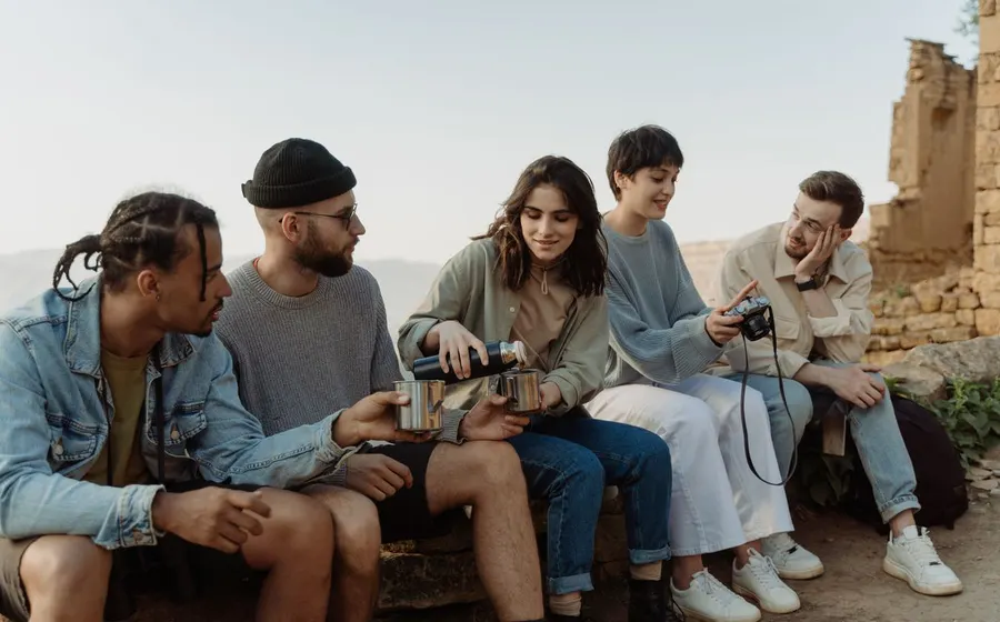 A multicultural group of travel friends relaxing together outdoors